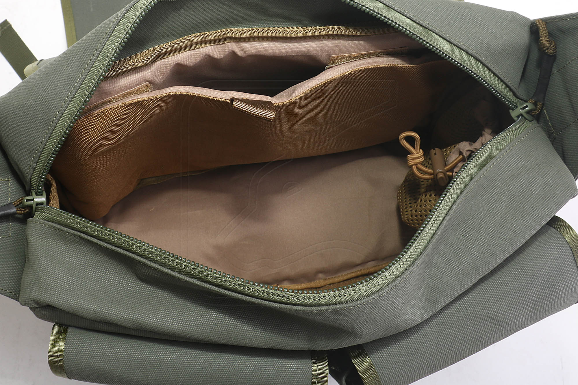 Open green tactical backpack showing organised compartments
